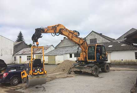 pelleteuse soulevant un  rouleau compresseur